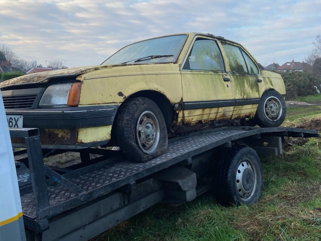 vintage nonrunner car on recovery truck